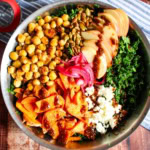 A bowl of harvest salad with the different toppings in groups on top of the kale.
