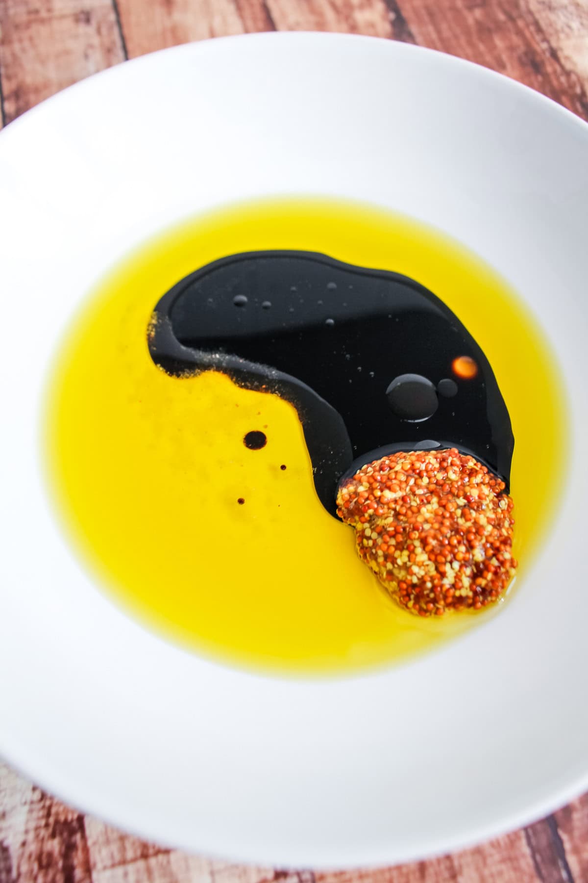 Ingredients in a bowl to make a simple mustard balsamic vinaigrette.