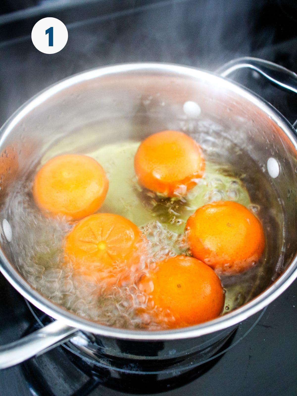 Boiling the whole clementines in a pot of water.