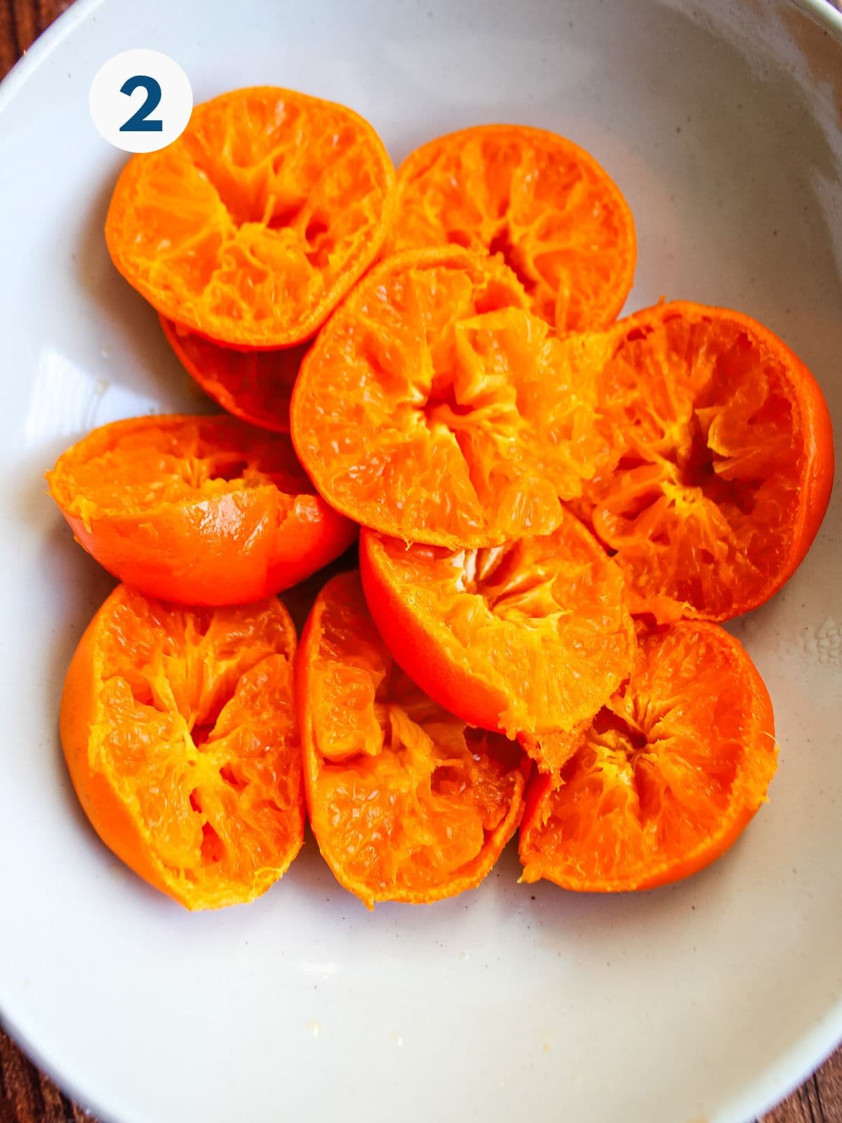 Cooked clementines cut in half in a bowl.